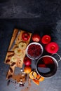 View from above. A board with apples, a pan with mulled wine, a plate with cranberries, dates, cinnamon and sugar.