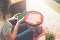 View from above. Young woman in glasses and striped T-shirt is sitting at home on couch and is using smartphone. Royalty Free Stock Photo