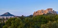 View of Acropolis hill and Lycabettus hill in background in Athens, Greece from Pnyx hill in soft summer sunset sky. Royalty Free Stock Photo