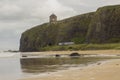 A view across Downhill beach in County Londonderry in Northern Ireland with a train heading toward the cliff tunnel Royalty Free Stock Photo