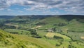 View across Edale valley and Kinder Scout plateau with white clouds and blue sky, Peak District, UK