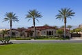 View across grass to facade of luxury suburban villa