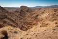 View across heavily eroded canyons in the New Mexico desert, distant mountain ridge