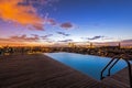 View across luxury roof top swimming pool to the city, with infinity edge, early morning sunrise, colorful sky in exotic Barcelona