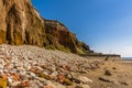 Major rockfalls from the white, red and orange stratified cliffs towards the sea wall at Old Hunstanton, Norfolk, UK Royalty Free Stock Photo