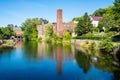 View across Opechee Bay Reservoir waters toward historic building with chimney, in Laconia, NH Royalty Free Stock Photo