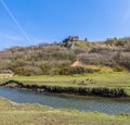 A view across the Pennard Pill stream towards the castle ruins at the Three Cliffs Bay, Gower Peninsula, Swansea, South Wales Royalty Free Stock Photo