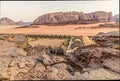 A view across the rocky terain over a campsite in the desert landscape in Wadi Rum, Jordan at sunset Royalty Free Stock Photo