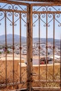 View across Thira on the Greek island of Santorini through wrought iron gates