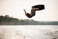 view on active male wakeboarder doing somersault in the air above water