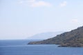 View of the Aegean Sea, mountains and rocks from the high shore near Marmaris, white sail and sailboat, Turkey, May 19 Royalty Free Stock Photo