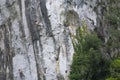 view from afar of a steep cliff in the . Italian Alps, small figures of rock climbers Royalty Free Stock Photo