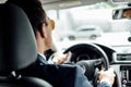 View of african american businessman in suit and sunglasses driving car Royalty Free Stock Photo