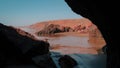 View of Aftas Beach from inside a cave. Waves of the Atlantic Ocean, sand, and rugged rock formations outside. Royalty Free Stock Photo