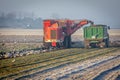 View of agricultural tractors harvesting in a field on a foggy day