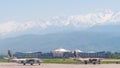 View from the airfield of Almaty on the Zaili Alatau. Various airplanes are parked on the airfield