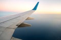 View from airplane on the aircraft white wing flying over ocean landscape in sunny morning. Air travel and transportation concept Royalty Free Stock Photo