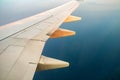 View from airplane on the aircraft white wing flying over ocean landscape in sunny morning. Air travel and transportation concept Royalty Free Stock Photo