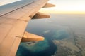 View from airplane on the aircraft white wing flying over ocean landscape in sunny morning. Air travel and transportation concept Royalty Free Stock Photo