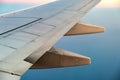 View from airplane on the aircraft white wing flying over ocean landscape in sunny morning. Air travel and transportation concept Royalty Free Stock Photo