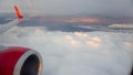 View from the airplane eluminator in flight on a beautiful sunset and white clouds under the engine and wing of the aircraft Royalty Free Stock Photo