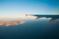View from the airplane over the sea, the mountains, the wing Royalty Free Stock Photo