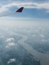 A view of clouds, a city and a river from an airplane