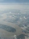 A view of clouds, a city and a river from an airplane