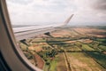 View from the airplane window of the fields and green meadows below Royalty Free Stock Photo