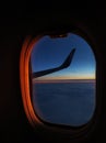 View from the airplane window flying over the sea at sunset