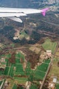 View from the airplane window on green fields and forests on the background of the wing Royalty Free Stock Photo