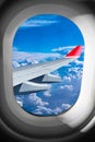 View through airplane window plane flight wing in front of blue white cloud sky. transportation air travel fly concept