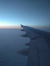 View from airplane window to beautiful sunrise or sunset. Wing of plane and clouds in the sky Royalty Free Stock Photo