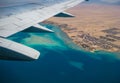 View from an airplane window to the Red Sea reefs and settlements on a deserted shore, Egypt