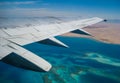 View from an airplane window to the Red Sea reefs and settlements on a deserted shore, Egypt