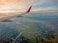 View from airplane window to see sky on Morning sunrise with Wing of an airplane.In Thailand, below is the Chao Phraya River and Royalty Free Stock Photo