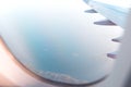 View from an airplane window to a wing during a daytime flight over the sea Royalty Free Stock Photo