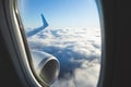 View from airplane window and the wing with sky over fluffy clouds. Flying and traveling concept background Royalty Free Stock Photo