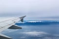 View from airplane with wing flying over Mt Olympus Greece with the snow-covered peak showing through a heavy fog Royalty Free Stock Photo