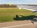 View of airplane wing, Shadow of the plane on the ground during landing, seen from the plane window Royalty Free Stock Photo