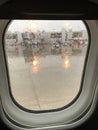 View of Airport terminal of an Airplane window on a rainy day Royalty Free Stock Photo