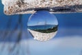 View on Akamas Peninsula national park through lens ball. Crystal ball photography. Detail on Latsi beach and Paphos Farhan Forest