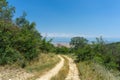 View of the Alazani Valley from a high mountain. Rocks and trees around. Earthen dirt road. Agrarian fields are visible. Clear Royalty Free Stock Photo