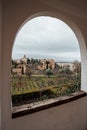 View of the Alhambra through a window in the gardens of the Generalife. Royalty Free Stock Photo