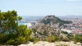 View of Alicante town, port, sea and Santa Barbara Castle on Benacantil mount from Serra Grossa mountain. Conifer tree