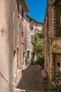 View of alley with stone houses and slope in Saint-Paul-de-Vence. Royalty Free Stock Photo