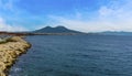 A view along the breakwater in the marina in Naples, Italy towards Mount Vesuvius in the distance Royalty Free Stock Photo