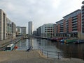 View along the clarence dock development in leeds with waterfront buildings reflected in the water boats and lock railings Royalty Free Stock Photo