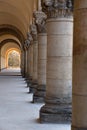 View along a neo-classical colonnade with old rough stone columns Royalty Free Stock Photo