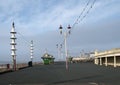 View along the pedestrian promenade in blackpool with traditional wooden shelters and lights with the town buildings in the